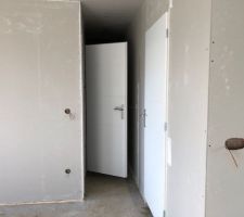 Salon vers couloir avec à gauche descente au sous/sol et à droite local ECS