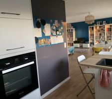 Cuisine vue sur le salon (mur gris tableau craie et bleu magnétique)