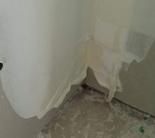Coulures d'enduit en bas des murs, avec les bandes de joint pas tout à fait recouvertes