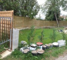 "muret" de d&eacute;limitation de terrain recevant sur elements de pilliers des panneaux bois ocultant en remplacement d'une bache sur piquets d'origine