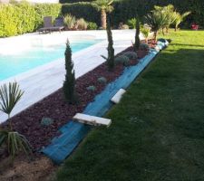 Mise en place de pouzzolane et de bordure le long de la piscine