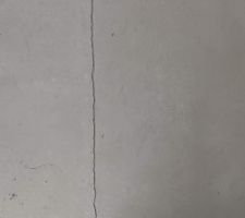 Le résultat, un fois la chape coulée et séchée. Fissure entre le salon et le couloir. Cette fissure se prolonge au niveau de l'ouverture du bureau.