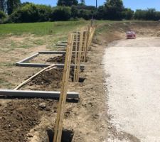 Clôture en cours de montage - on marque l'emplacement des trous avec des tasseaux qui nous servent à tenir les poteaux béton bien droits pendant que le béton prend