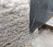 Partie basse de la porte d'entrée côté extérieur : Petit trou entre le seuil en alu et la partie inférieure en béton. La finition laisse à désirer.