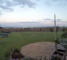 Le jardin en contre bas d ela cour gravillonée  on y voit la plage de sable , le verger  et les jardinièresXXL du potager  les poireaux y poussent très bien cet année