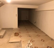 Pose collée du carrelage du sous-sol en cours