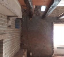 Découverte d'un enduit ciment projeté sur mur sud, dans le salon. Pff!