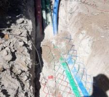 Mise en tranchée des fourreaux d'adduction. Vides, sauf celui pour l'eau potable qui a déjà son PEHD. En revanche l'écart entre les tubes demandé par les DTU n'est pas respecté, la tranchée n'est pas assez large.
De même, les grillages avertisseurs ne sont pas très loin au dessus des gaines, les 10cm ne sont pas toujours respectés.