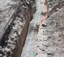 Mise en tranchée des fourreaux d'adduction. Vides, sauf celui pour l'eau potable qui a déjà son PEHD. En revanche l'écart entre les tubes demandé par les DTU n'est pas respecté, la tranchée n'est pas assez large.
De même, les grillages avertisseurs ne sont pas très loin au dessus des gaines, les 10cm ne sont pas toujours respectés.