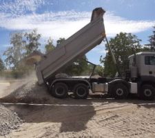 Livraison du recyclé béton qui fera la forme sous le radier du garage.
On tasse en 2 fois, donc on met la moitié dans le trou du garage, l'autre moitié attendra à côté.
