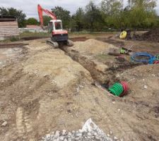 Fin de la tranchée du puits climatique, et passage des gaines pour le garage. Il a fallu les passer sous la minipelle, qui est coincée au-dessus de sa tranchée tant qu'elle n'est pas rebouchée.