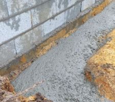 Résultat après 4 toupies de gros béton, et un peu d'eau ajoutée dans la toupie par les maçons. Au vue des flaques d'eau (il a encore plu aujourd'hui, comme prévu), ça ne semble pas vraiment de niveau.
le gros béton arrive juste en dessous de la fondation du voisin