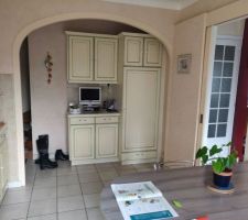 Une vue de la cuisine avec un acc_s à droite vers le salon depuis une porte à galandage