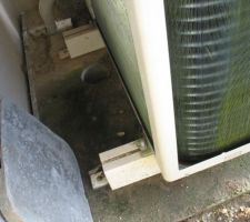 Vue de la pompe a chaleur avec sa dalle et une évacuation qui ne sert à rien car il n'y a aucune pente pour que l'eau s'écoule dans le tuyau