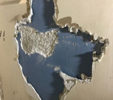 Du placo en surface collé par du map.
En dessous, du plâtre peint en bleu, et dessous, du ciment ?