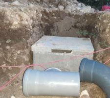 Regard d'évacuation des eaux pluviales et du drain en place. Il y a un fond de regard de 30cm de haut dans lequel arrivera le drain, une réhausse (qu'on voit ici) de 30cm dans laquelle arrivera les eaux pluviales, et le couvercle.