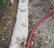 Fermeture du geotextile sur le boudin de galets, en rabattant bien les 2 morceaux l'un sur l'autre.