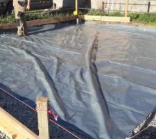 Déroulement du polyane sur la dalle. Il fait 6m de large, presque la taille de notre garage. Seulement les murs ne sont pas rectangulaires, on devra rajouter quelques coupes en triangle.