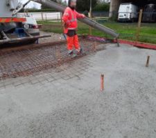 Coulage du radier. Le béton S4 est relativement liquide et s'étale bien. A 2 on y arrive sans trop d'efforts. Les piquets devaient me servir à faire le niveau, mais ils ont été inutiles voire contre-productifs.
Il aurait fallu une 3ème personne pour pouvoir nous faire le niveau avec le laser.