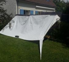Récupération d'une bâche de tente pergola pour protéger les cultures du vent et de la pluie.