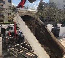 Livraison de terre végétale devant la maison pour le jardin arrière