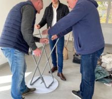 Olivier, Geoffroy et Romain montent une petite table pour poser les documents à nous remettre.