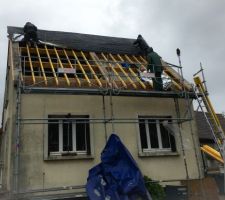 Pose de l'isolant sous toiture sous la pluie.