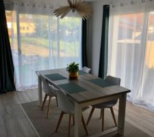 Suspension artisanale en bois naturel au dessus de la table.