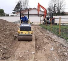 Compactage des tranchées rebouchées. On a amené le concassé béton légèrement plus haut que le sol (argileux) autour, et on passe doucement avec la vibration. On sent quand même que le rouleau est moins puissant que celui qu'on a eu l'été dernier. Depuis la dalle du garage, je ne sens pas les vibrations sauf si le rouleau arrive vraiment devant moi.