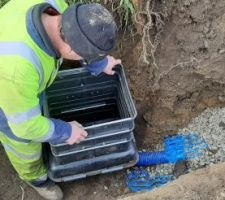 Connexion de l'eau potable : mise en place du regard de comptage. En bas à droite, l'arrivée de l'eau du réseau sous la route. A gauche, mon PEHD (et on voit aussi une gaine telecom). Les employés de la communauté de communes ont été sympa et m'ont branché mon tuyau, je n'ai pas eu à le faire et c'aurait été galère sinon. Il ne manque plus que le compteur et j'ai l'eau.