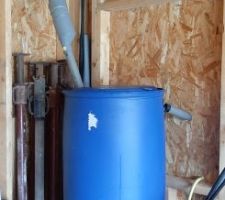 Déplacement de la cuve de récupération temporaire. On fait passer les tuyaux par la future fenêtre. Pour la connexion à la descente j'ai improvisé.