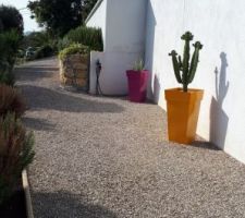 Côté Sud quasi terminé, allée de plus de 40 m en gravier avec bordure, Grand pot de couleur que nous avons achetés blanc et que nous avons fait peindre par un carrossier de plusieurs couleurs