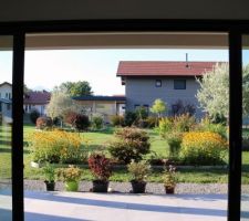 Depuis l'intérieur du salon, l'un des canapés ne regarde pas la télé, mais le jardin, et en entrant dans la maison c'est cette vue qu'on a (porte d'entrée alignée sur la baie principale, au fond)