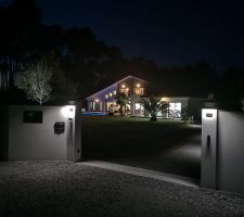 La maison vue de nuit depuis l'extérieur de la propriété.