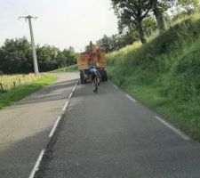 Et on est parti. Un vélo s'est inséré entre le convoi et mon camion. Au final, on ne le ralentis pas, mais il arrive à tenir la cadence pendant plusieurs kilomètres, sur toute la montée. Il nous doublera ensuite sur la 1ère descente, après avoir "attrapé le pompom" (tapé dans la couverture rouge) comme un gosse au manège. Chapeau, c'était pas simple !