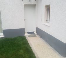 Entrée classique, avec une allée en béton désactivé. Juste un petit plaisir: une grille sur un petit trou juste devant la porte, pour pouvoir se taper les pieds
