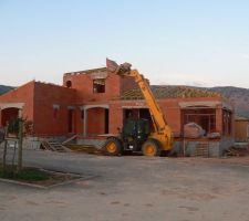 Vue d'ensemble de la maison avec la charpente en cours de pose