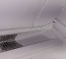Le trou au fond du frigo bouché par une tôle perforée anti-rongeurs, complément par dessus