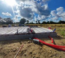 Vue arrière de la maison avec le garage à droite et la cuisine qui commence là où se trouve les hourdis en PVC
