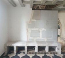 La cheminée d'origine tirait beaucoup...trop ! Nous l'avons donc fait détruire par le couvreur. Pour accueillir le futur poêle, nous avons remonté un mur et créé un banc. Tout ceci en béton cellulaire (PointP et Leroy Merlin, selon état de leurs stocks)