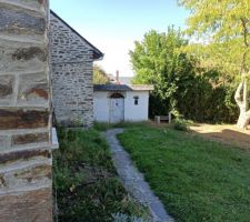 Vue de l'arrière avec le petit chemin en ardoise, la jardinière sur la gauche, et au fond à droite le magnifique albizia