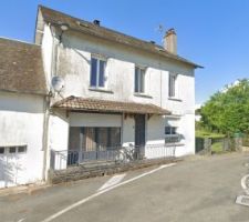 La façade sud de la maison, qui donne sur la rue. 
Aucune idée sur la raison qui a poussé un des anciens propriétaires à mettre ce vilain crépi sur la jolie pierre, mais une chose est certaine, si on peut le faire sauter et retrouver la pierre, on ne va pas se priver ! 

On voit une petite avancée avec une rembarde, pour l'instant on va laisser comme ça et mettre des gros pots de plantes. 

À terme pourquoi pas une avancée vitrée en mode petite véranda ?