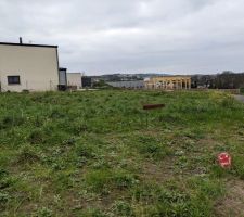 Vue du terrain, l'implantation de la maison est r&eacute;alis&eacute; avec des chaises dispos&eacute;es aux extr&eacute;mit&eacute;s du terrain pour permettre au terrassier de venir creuser les fondations.