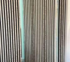 Porte dissimulée derrière panneaux acoustiques