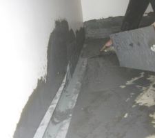 On noie la bande dans l'enduit d'étanchéité