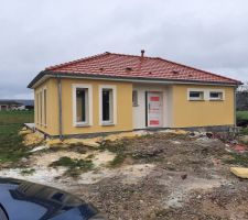 Couleur jaune Dune pour les murs et jaune Orpiment pour les contours des fenêtres et l'entrée. Façade avant.