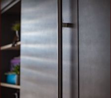 Aménagement d'un dressing sous mansarde avec porte cachée. Détail de la poignée de porte faite maison, style bâton de maréchal.