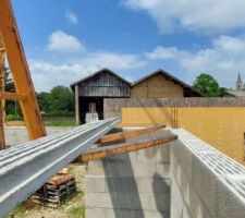 Dépose des poutrelles sur les murs à la grue.