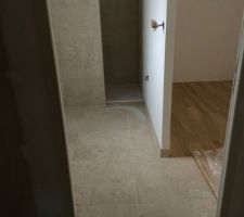 Carrelage travertin salle de bain et jonction parquet bois dressing et carrelage carreau de ciment dans l?entrée.