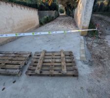 Entr&eacute;e du chemin avec bordure en pav&eacute;s, prot&eacute;g&eacute;s par des palettes. Et la condamnation du chemin en attendant la stabilisation compl&egrave;te de l'ensemble pour une meilleure long&eacute;vit&eacute;.